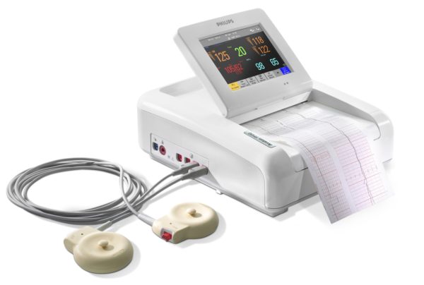 Der Philips Avalon FM30 Fetalmonitor ist mit zwei Aufnehmern dargestellt. Der integrierte Drucker druckt ein EKG aus., die Vitalparameter werden auf einem Dispplay angezeigt.