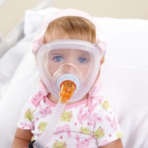 Philips Respironics PerforMax klein - Kleines Kind mit Beatmungsmaske sitzt in Bett.